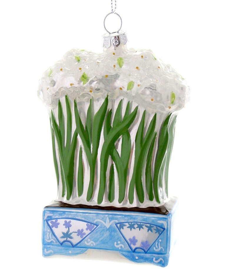 A glass ornament in the form of a chinoiserie planter holding blooming paperwhite narcissus.