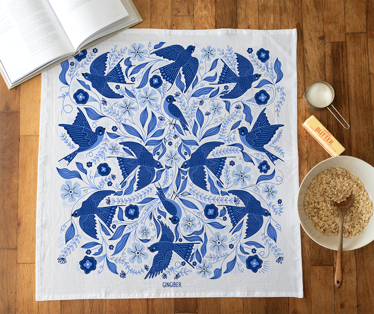 A cotton flour sack towel with an allover pattern featuring blue songbirds.