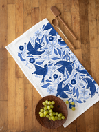A cotton flour sack tea towel featuring a bold graphic of blue songbirds.