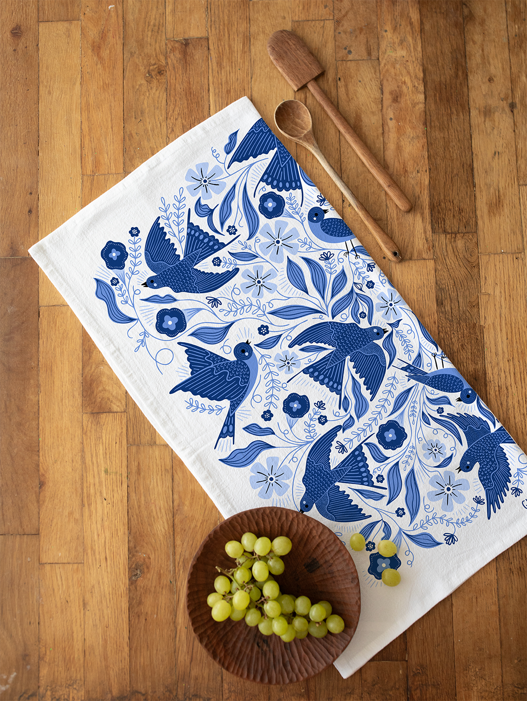 A cotton flour sack tea towel featuring a bold graphic of blue songbirds.