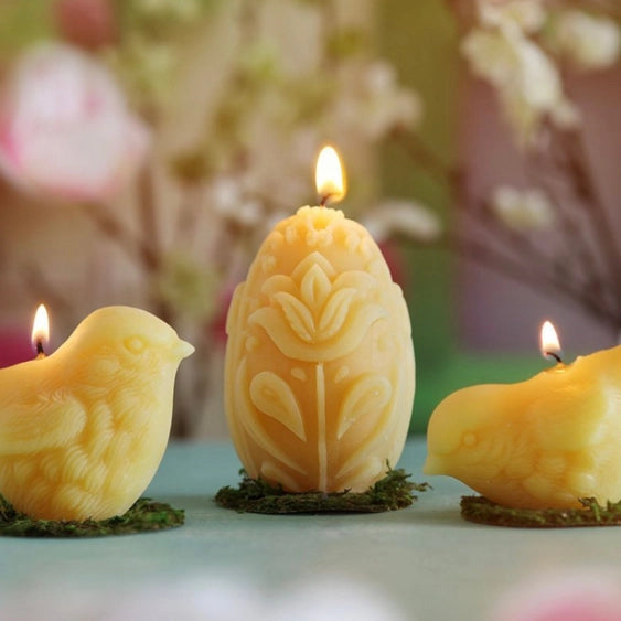 Sculpted beeswax candles by Big Dipper Wax Works include the egg shaped votive with tulips and leaves.