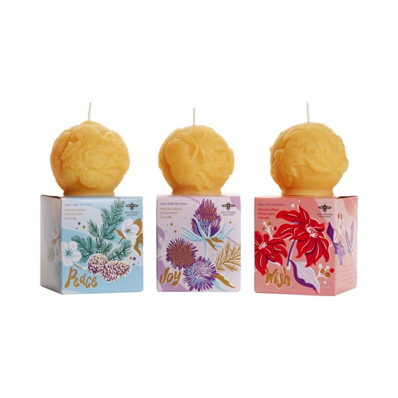Sculpted beeswax candle ornaments by Big Dipper Wax Works include "joy", "peace", and "wish".