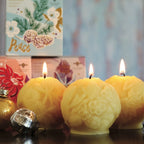 Sculpted beeswax candle ornaments "joy", "peace", and "wish", each with a unique carved floral design.