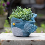 A woolen hand felted pot cover in the form of a sleepy blue bird.