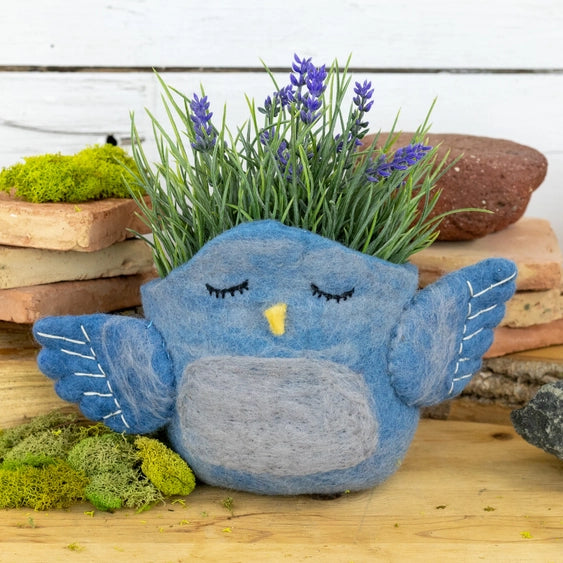 A woolen felted pot cover in the form of a bluebird.