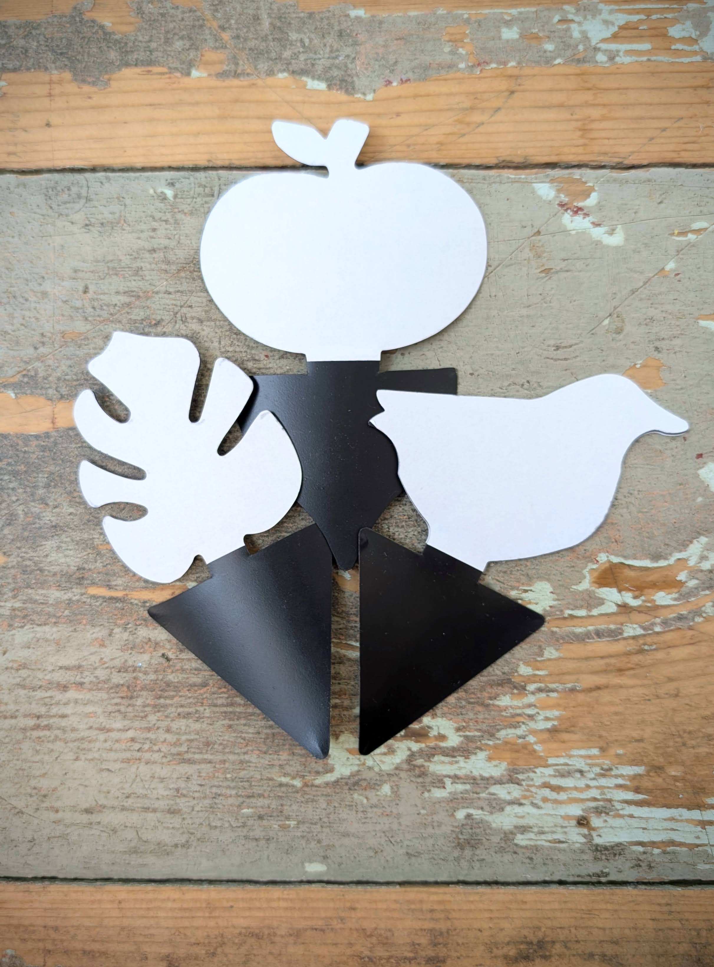 Three shapes of black sticky gnat trap are displayed, an apple, a bird, and a monstera leaf.