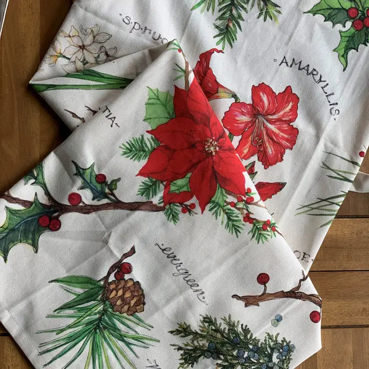 The Holiday Blossoms Kitchen Towel from Bulb & Blossom features festive illustrations of botanicals.
