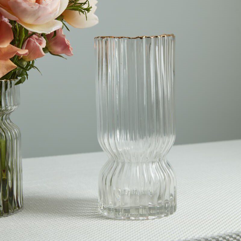 The Odette Bulb Forcing Vase features clear fluted glass with a gold-rimmed edge.