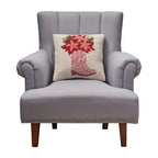 A woolen needle hook throw pillow featuring pink cowboy boots filled with red amaryllis flowers.
