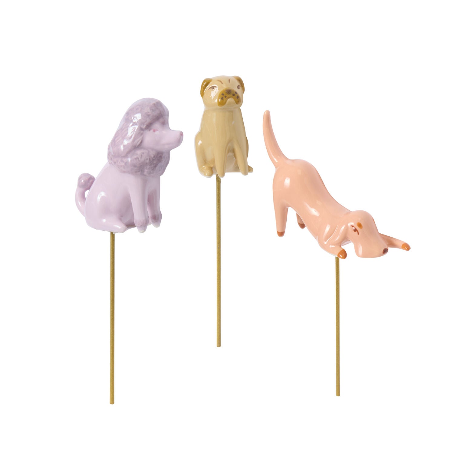 Three ceramic dog figurines on sticks in pastel colors on a white background