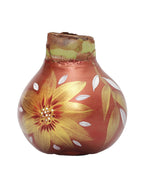 An unsprouted waxed amaryllis bulb that is hand painted with gold and white sunflowers against a base color of copper.