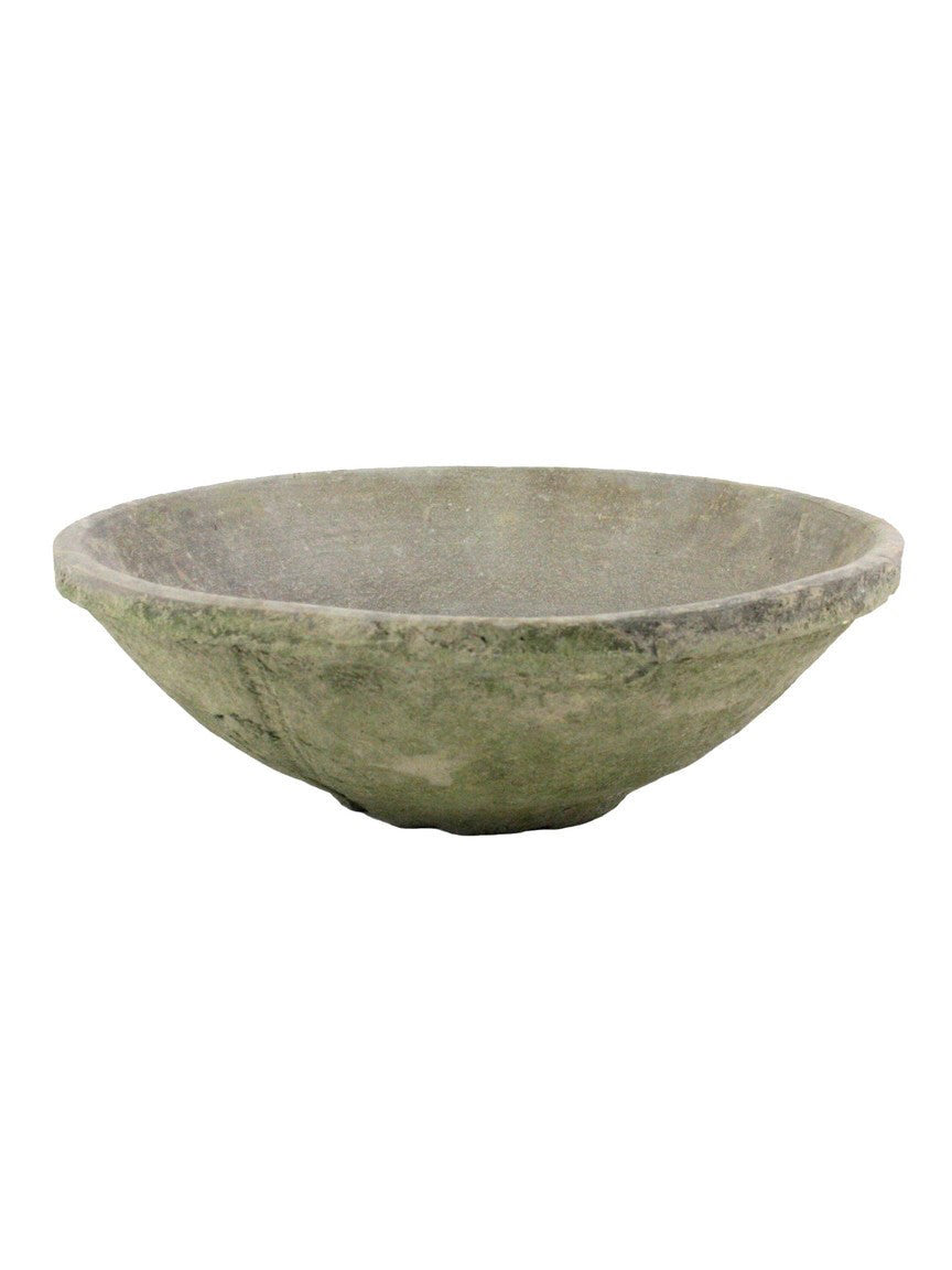 A rustic, handcrafted stone bowl with a textured, weathered finish in muted gray-green tones, isolated on a white background.