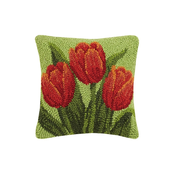 A woolen needle hook throw pillow featuring three red tulip blossoms.