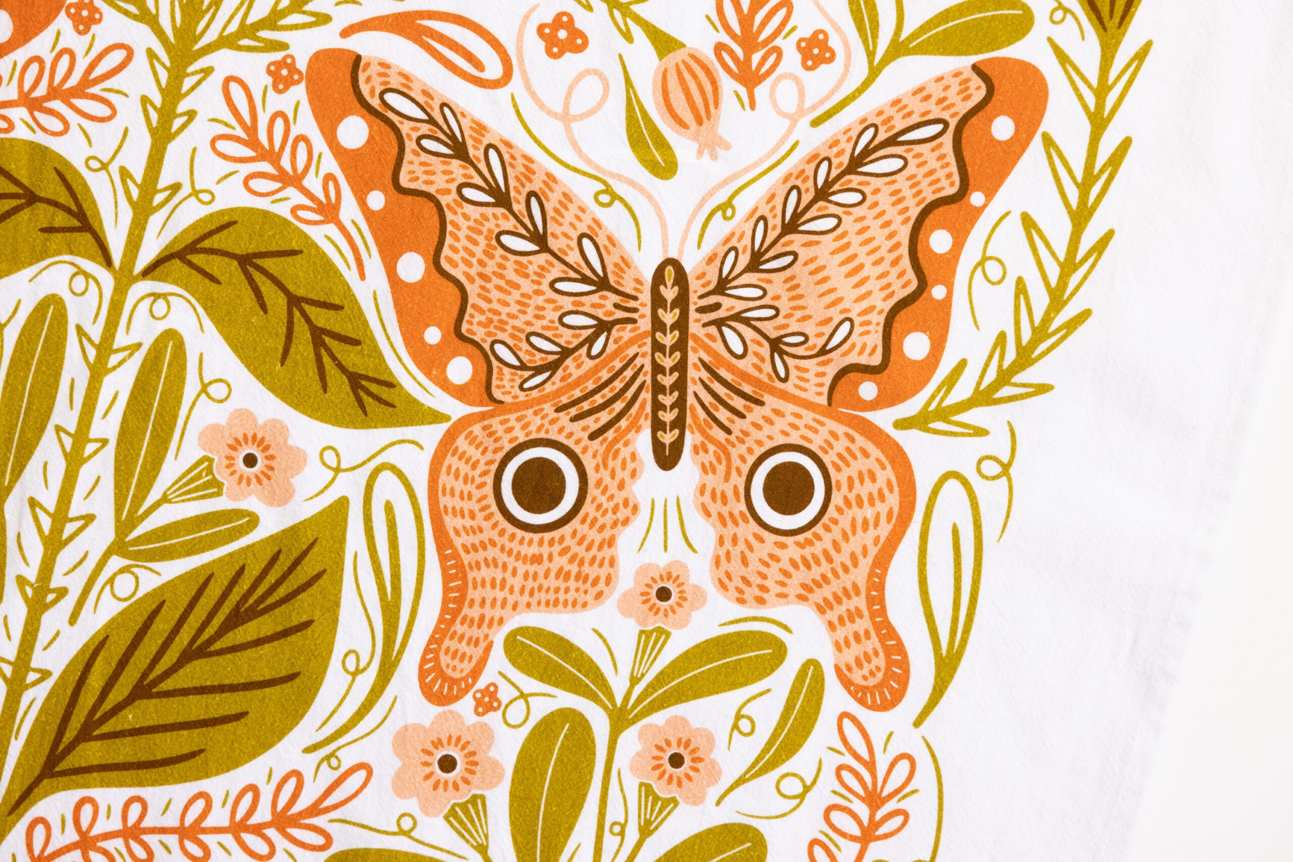 An illustration of an orange butterfly with decorative patterns among green and peach leaves and flowers on a white background, featured on our Vintage Butterfly Flour Sack Tea Towel.