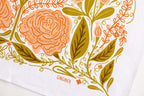A close-up of the Vintage Butterfly Flour Sack Tea Towel shows an illustrated floral pattern in orange and olive green, with large stylized flowers, leaves, and vines. "GINGIBER" is printed at the bottom center.