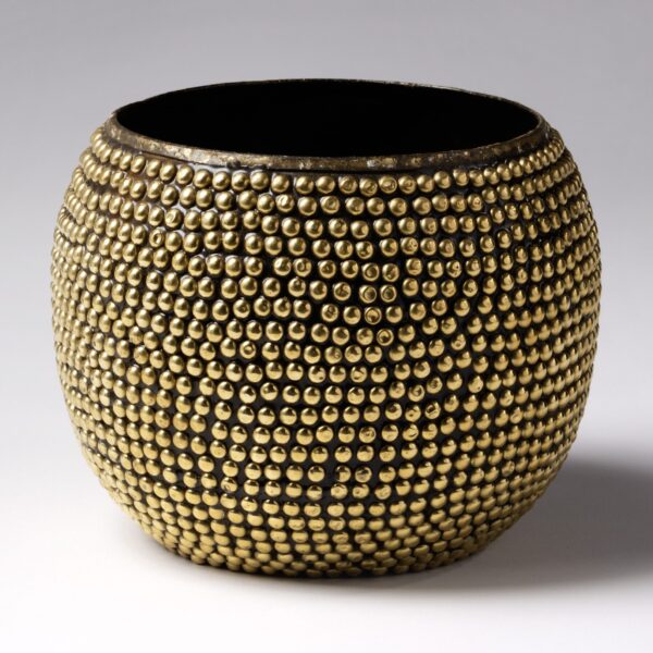 A rounded, gold-colored vase featuring a dense pattern of small, raised, metallic spheres covering its surface. The vase has a wide opening at the top and a textured, reflective design, standing against a plain gray background.