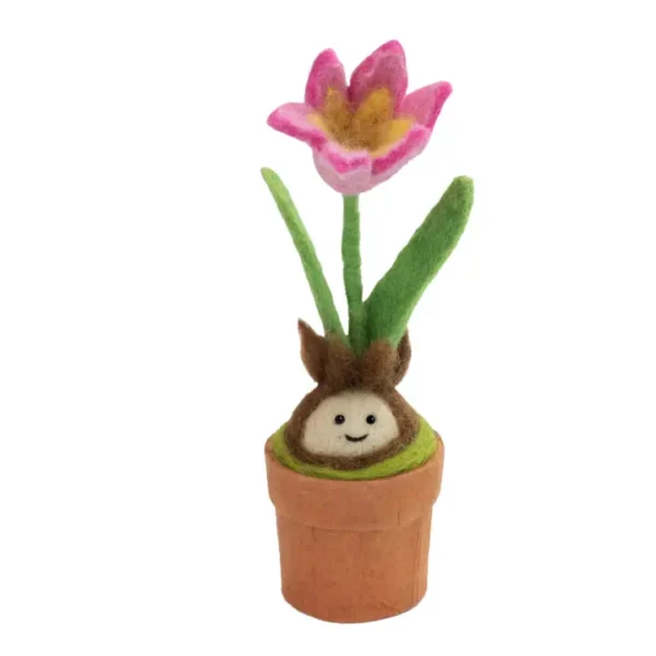 The Felted Tulip Blossom Buddy is a small flower in a pot, featuring pink petals, green leaves, and a smiling bulb character at the base—all crafted from soft felt material.